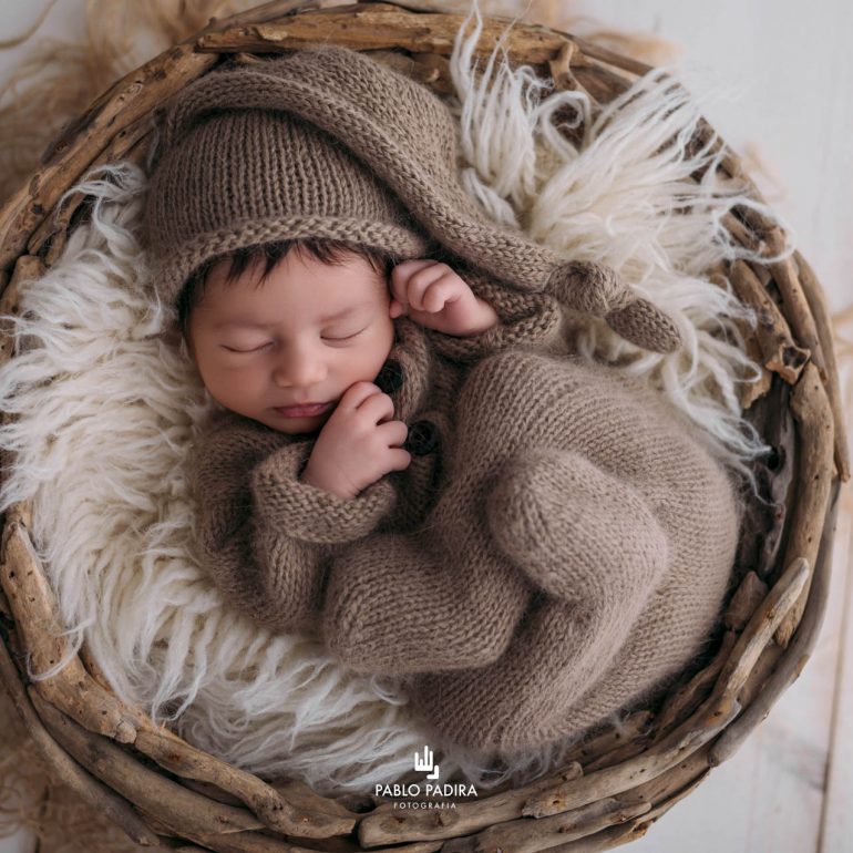 Recién nacido dormido sobre un cesto de ramas durante la sesión de fotografía newborn en San Fernando, Cádiz